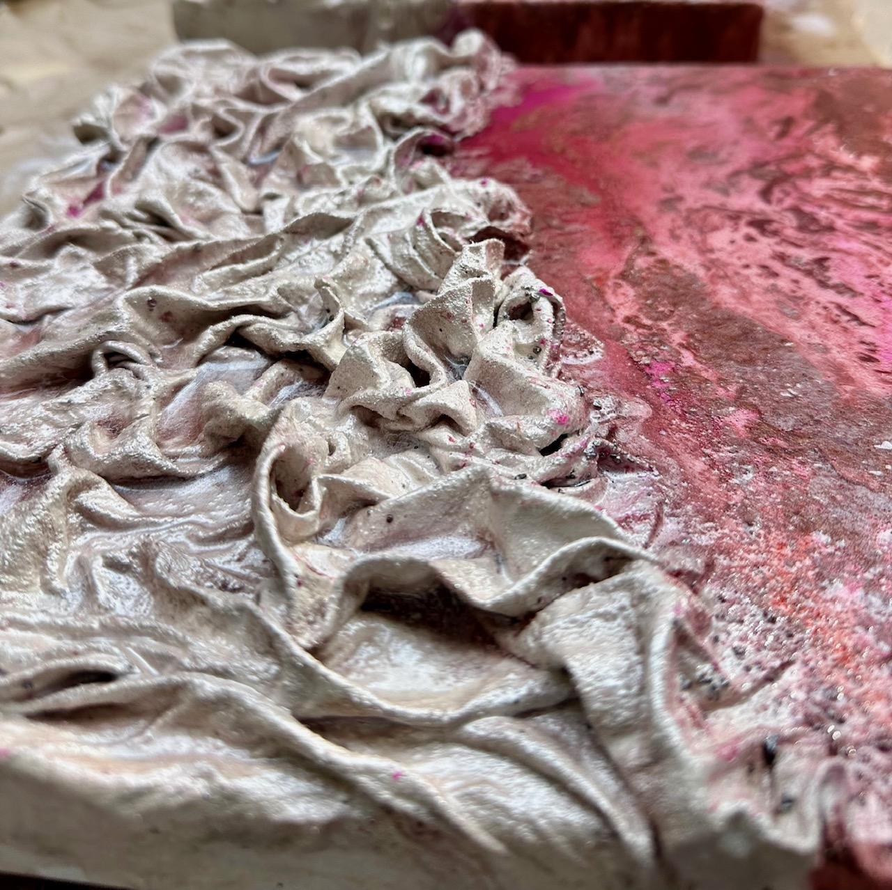 Close-up of blush and grey sculpted folds in heavy medium