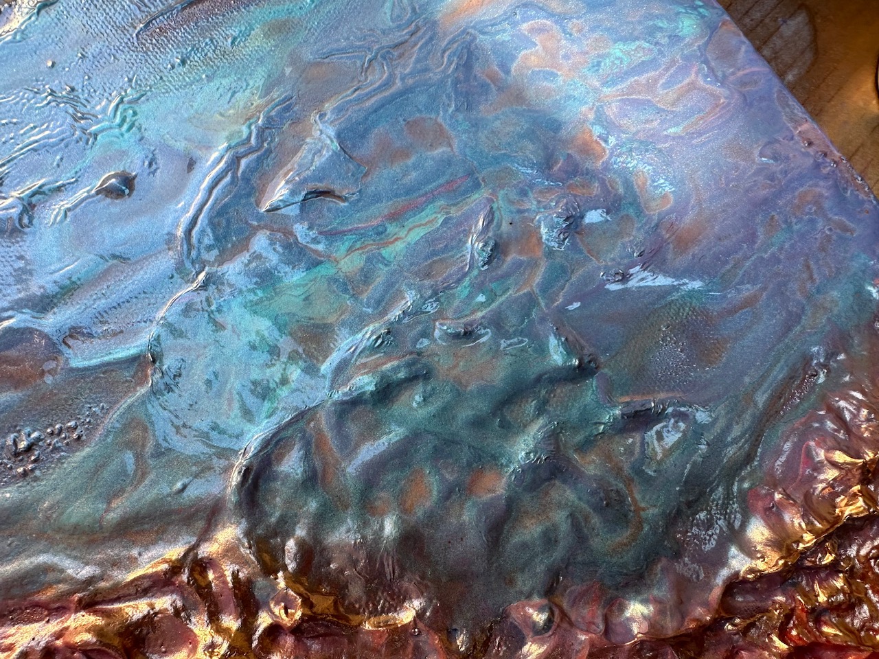 Close-up of violet and blue poured texture drying on canvas